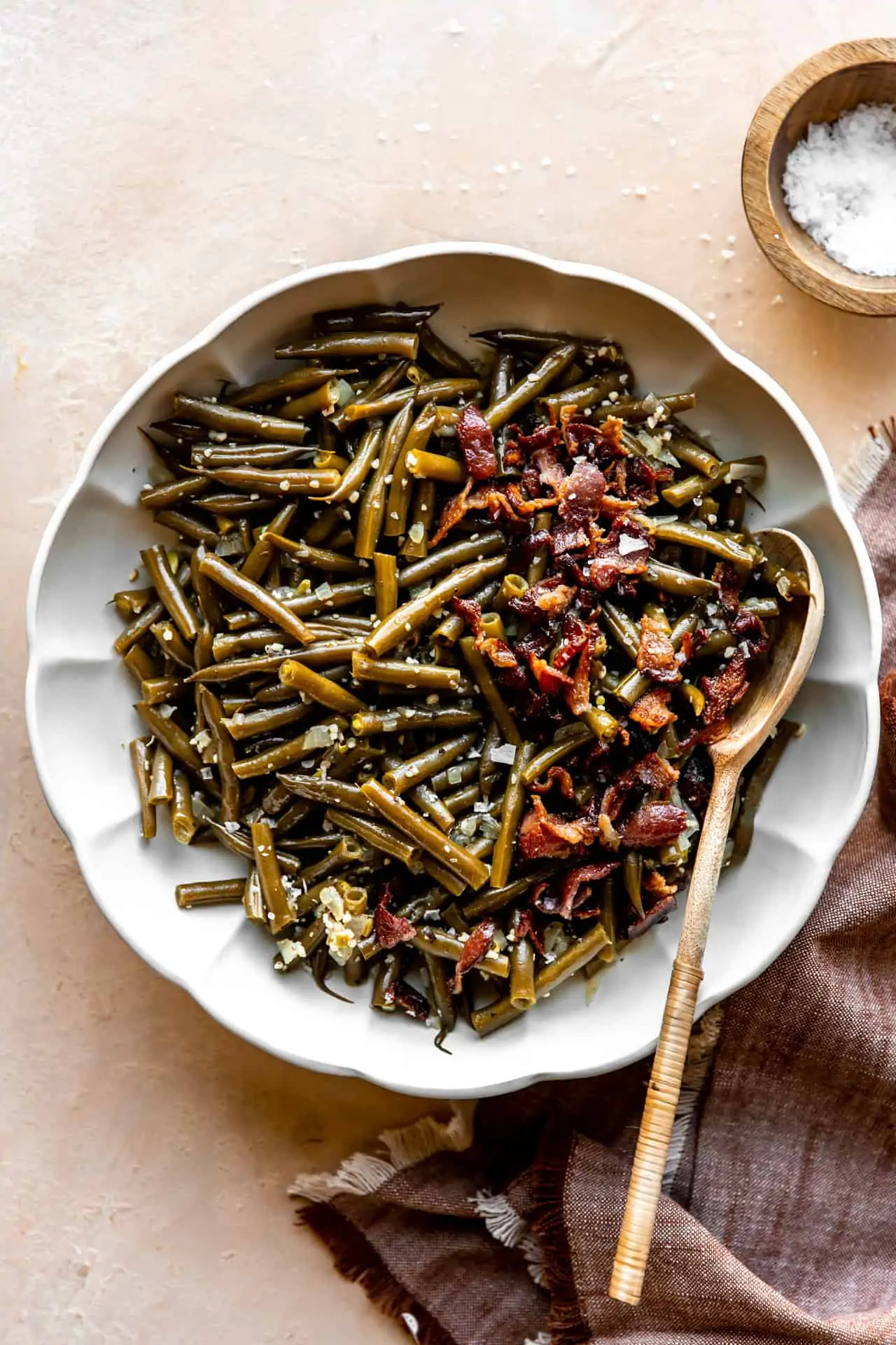 Dish of southern green beans topped with crispy bacon.