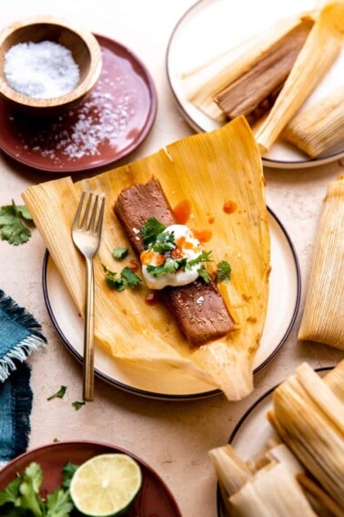 Pork tamales topped with sour cream, cilantro and hot sauce.