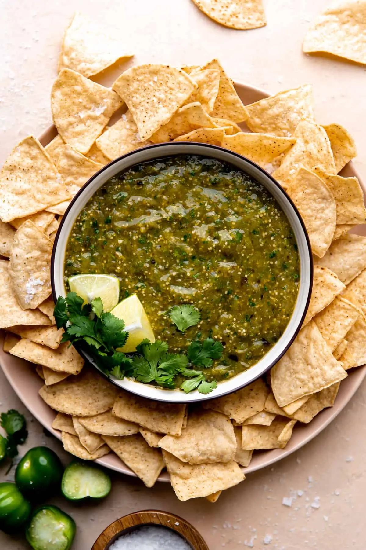 Bowl of homemade salsa verde surrounded by tortilla chips.