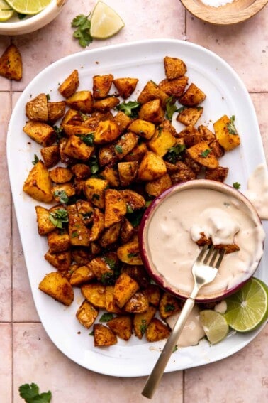 Plate of roasted tex mex seasoned potatoes served with queso.