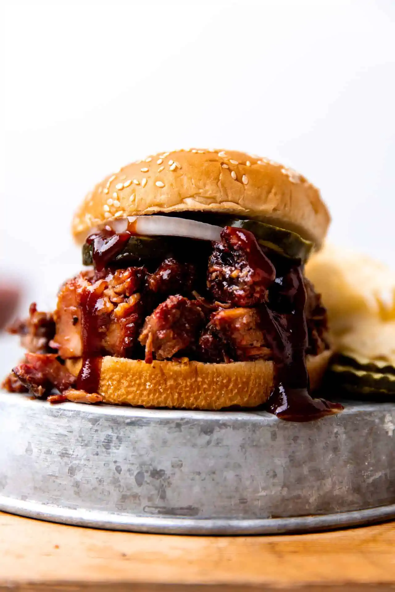 Up close view of chopped brisket sandwich with pickles. 