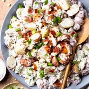 Overhead view of creamy red potato salad being served with a spoon.