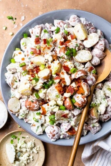 Overhead view of creamy red potato salad being served with a spoon.