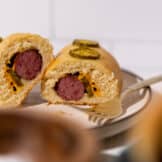 Cut open kolache with sausage, jalapeno and cheese.