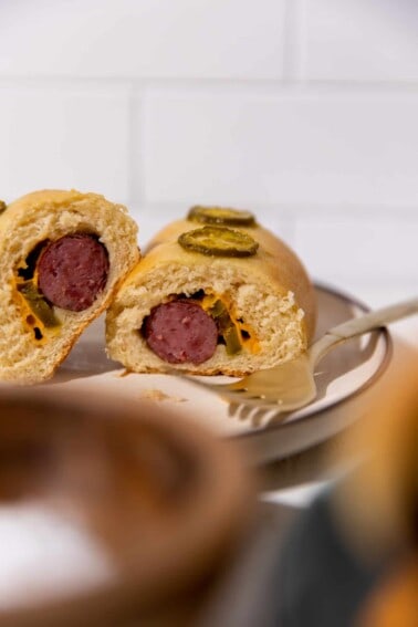 Cut open kolache with sausage, jalapeno and cheese.