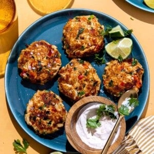 Plate of Tex Mex seasoned crab cakes on a plate served with a creamy sauce.