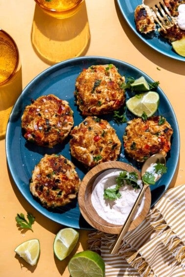 Plate of Tex Mex seasoned crab cakes on a plate served with a creamy sauce.