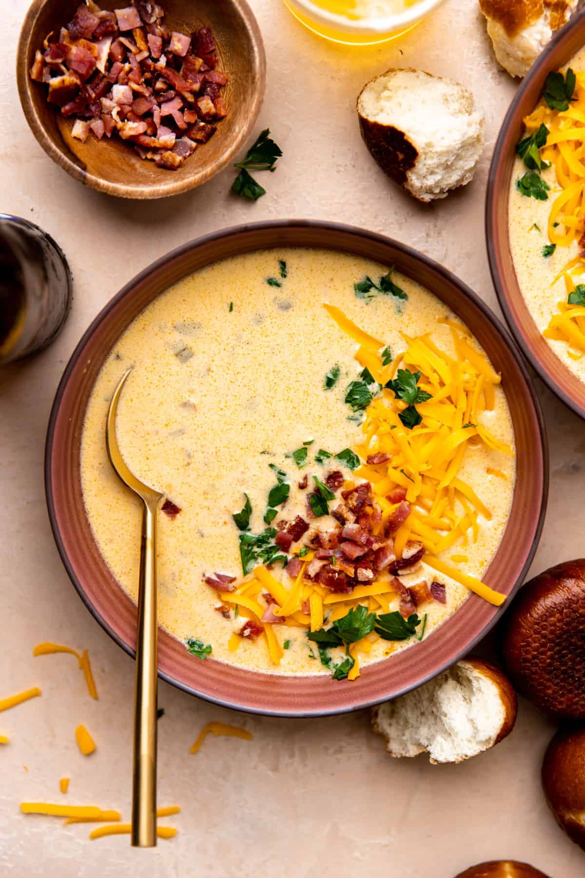Bowl of beer cheese soup ready to serve with bacon, cheese and fresh parsley on top.