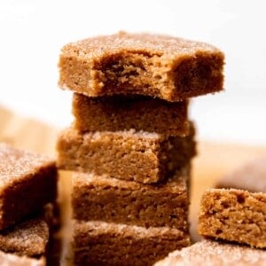 Stack of cinnamon churro bars, stacked with a bite out of the top one.
