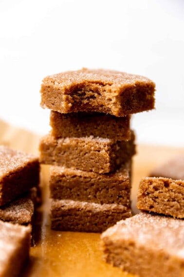 Stack of cinnamon churro bars, stacked with a bite out of the top one.