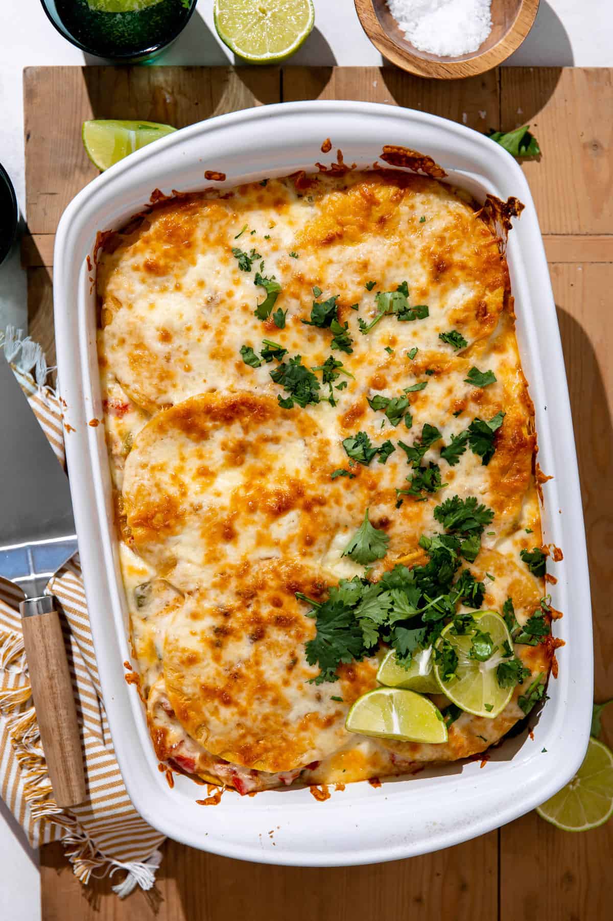 Baked King Ranch Chicken Casserole in a baking dish topped with fresh cilantro and lime wedges. 