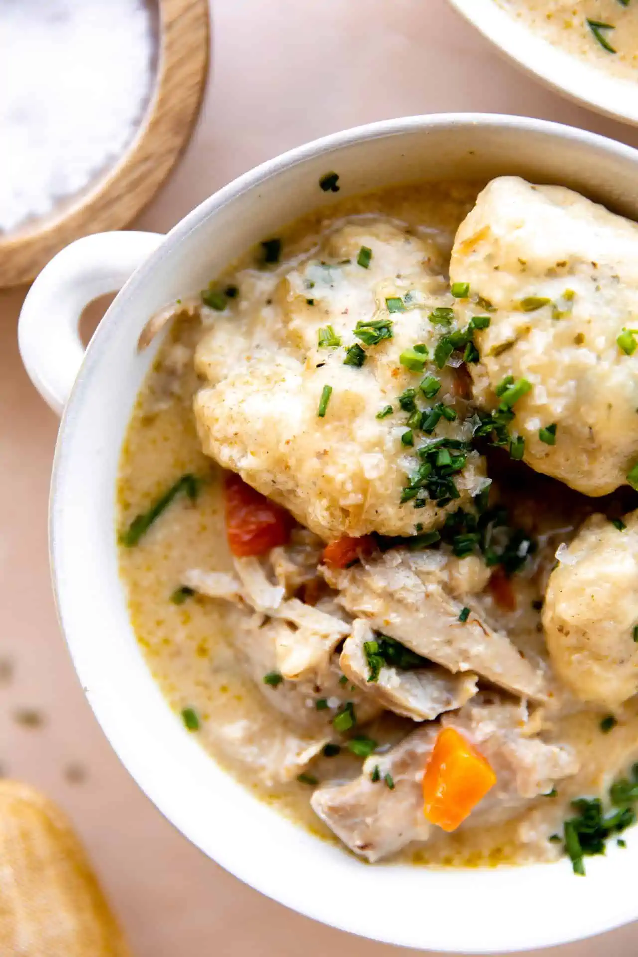 Up close of biscuit dumplings on top of chicken soup.