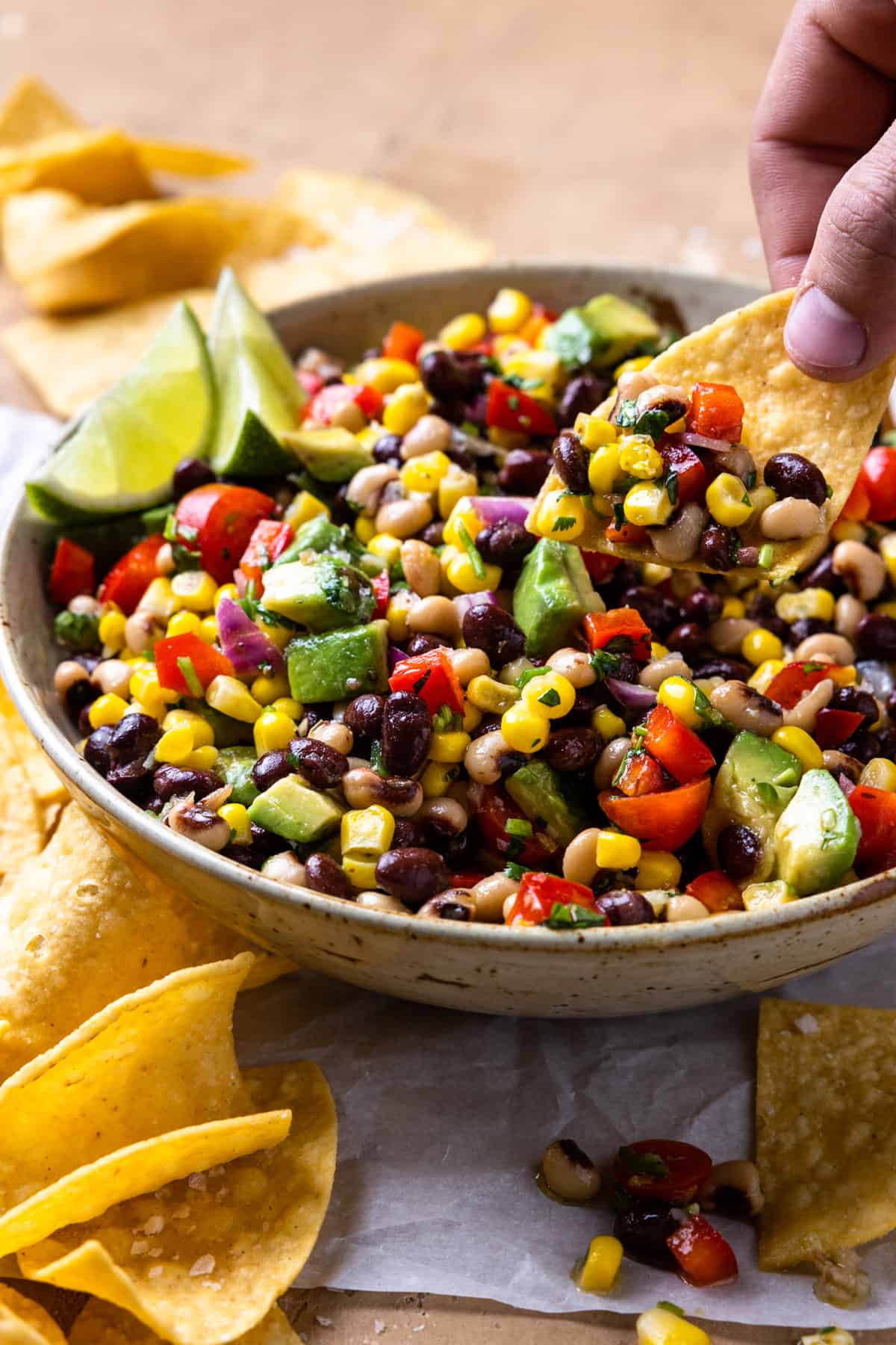 Dipping tortilla chips into a bowl of Texas Caviar.