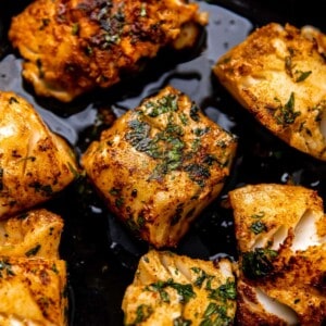 Fish searing in a cast iron skillet.