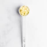 Measuring spoon with minced garlic.