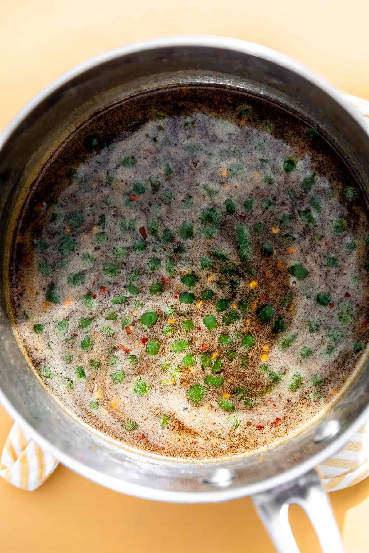 Hot honey glaze with jalapeño cooking in a saucepan.