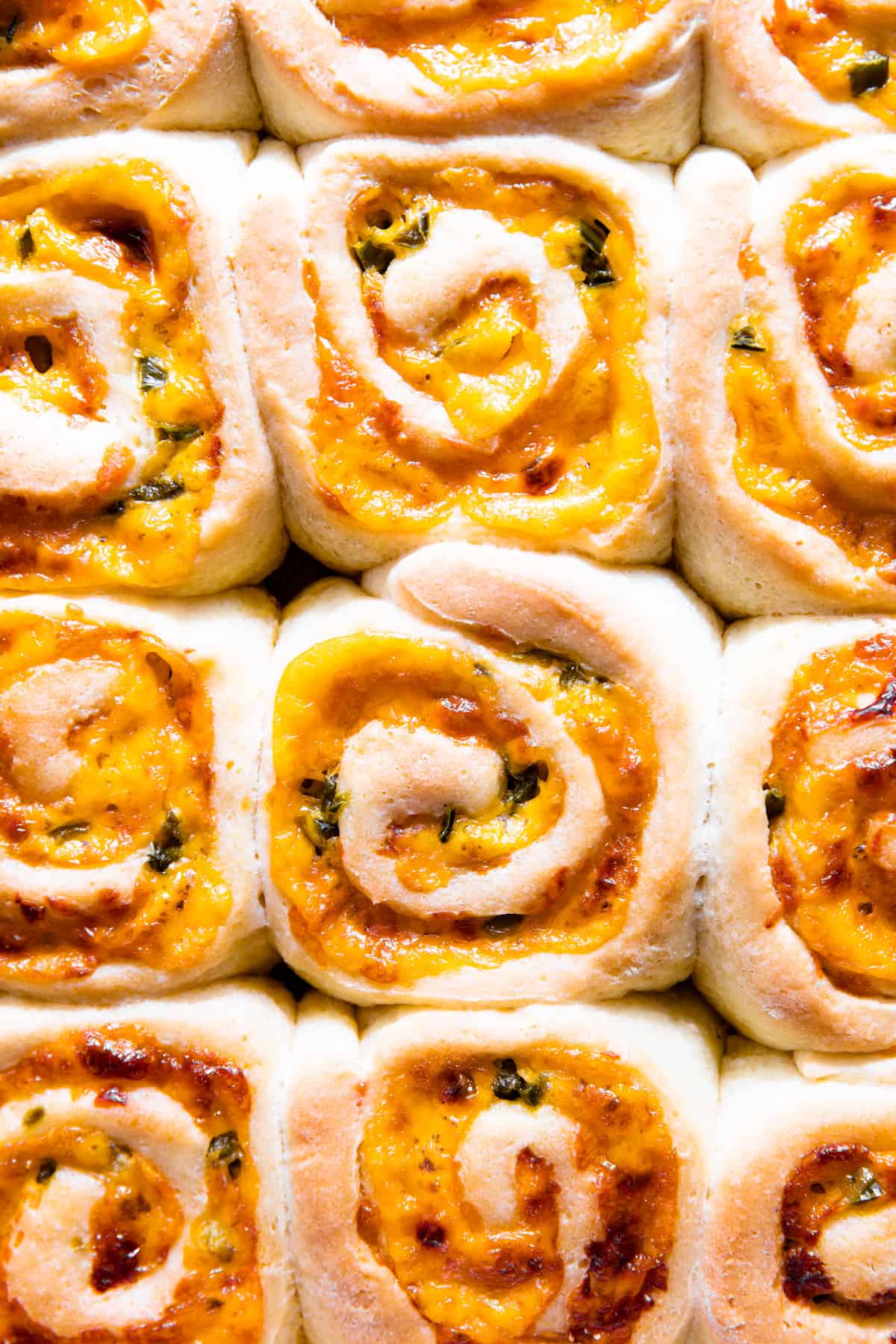Up close view of fluffy cheese rolls with diced jalapeno.