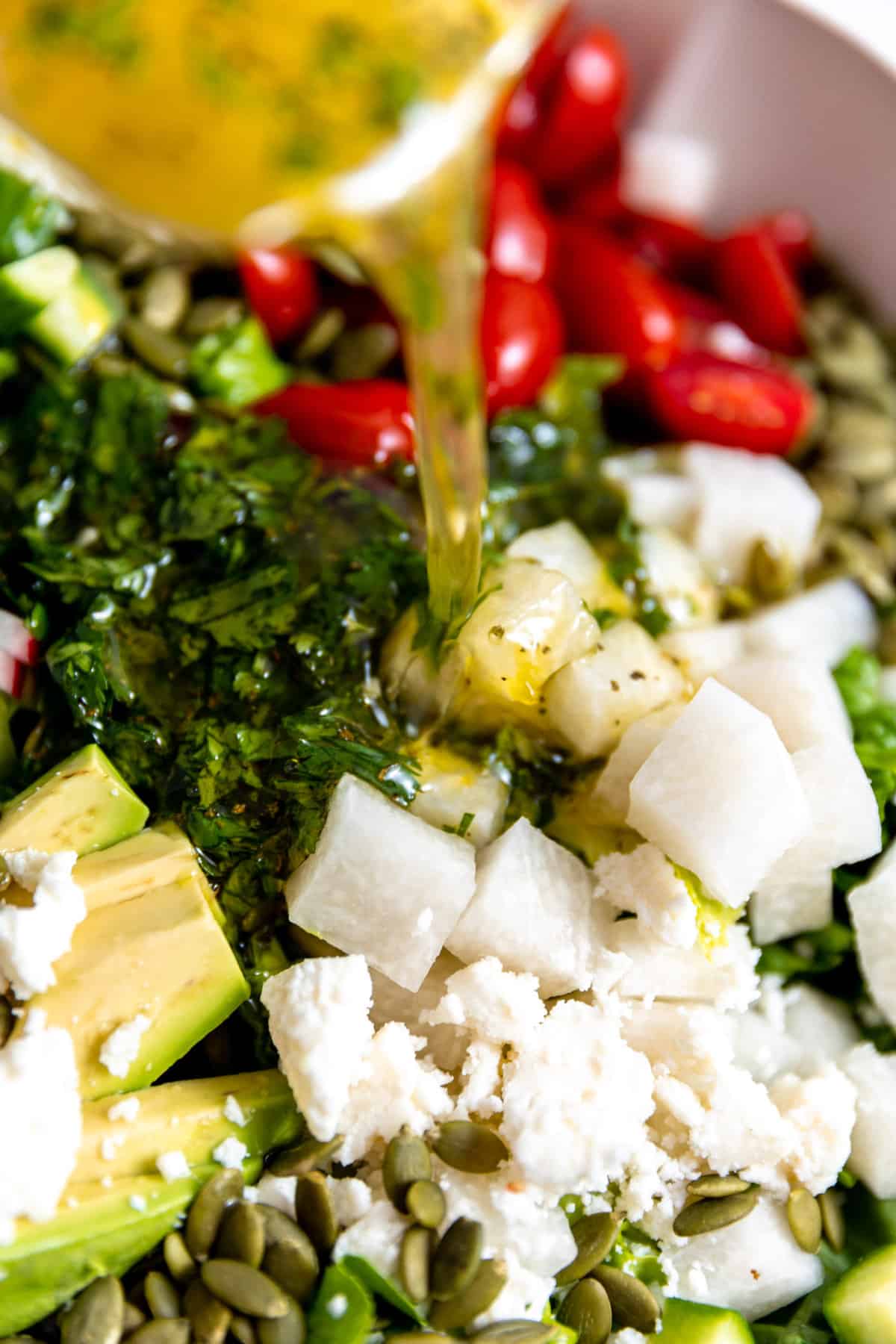 Dressing pouring over a salad.