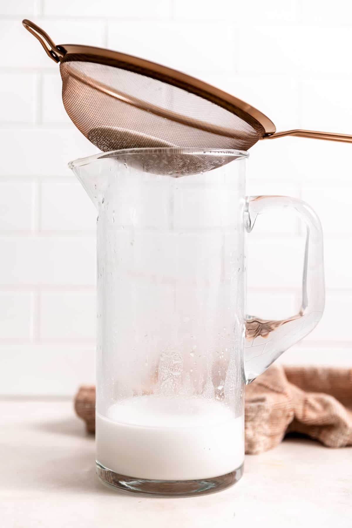 Strainer on top of a pitcher to strain out the silt from blending rice to make rice milk.