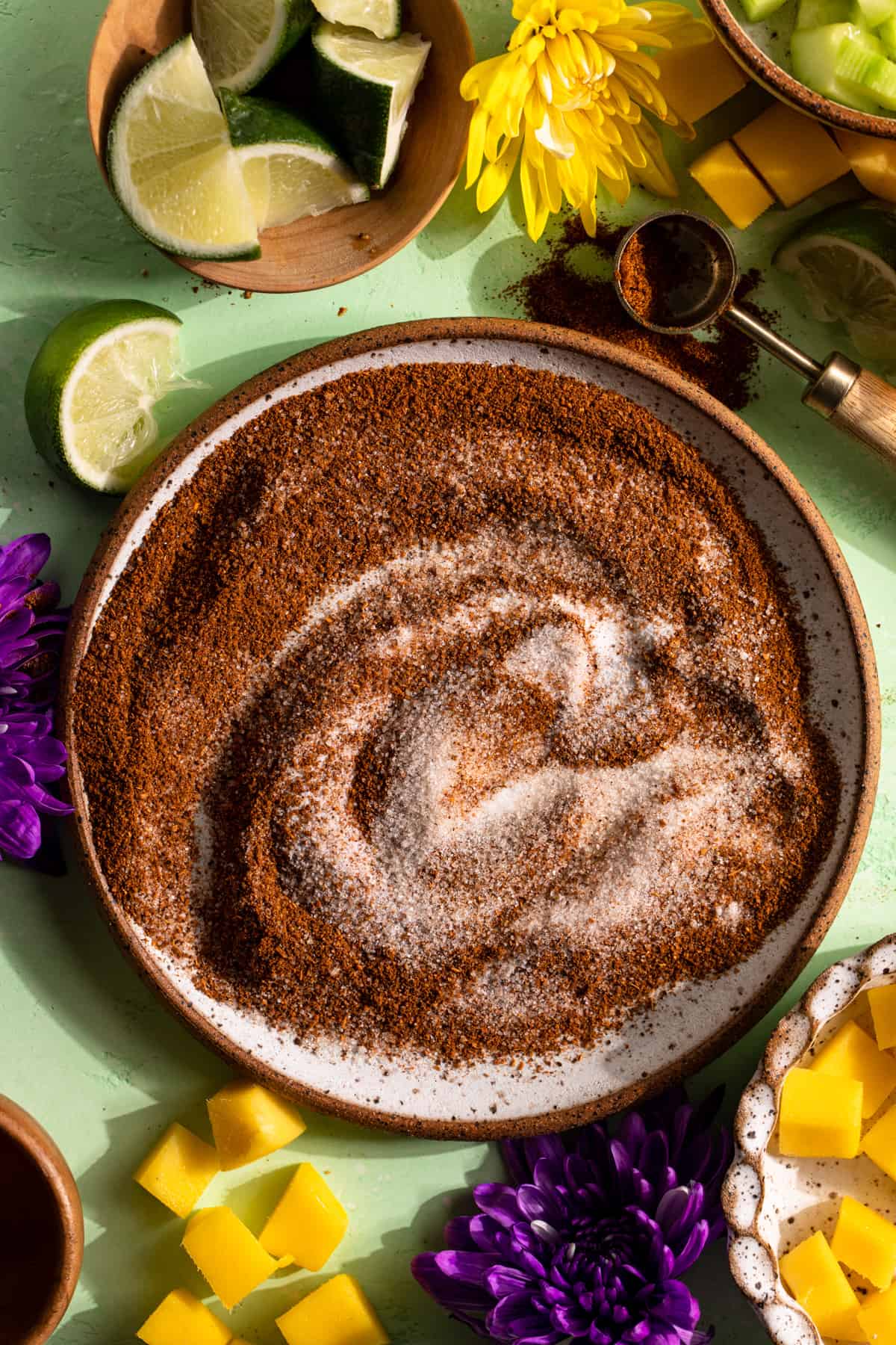 Spices, lime, and salt swirled on a plate to make homemade chili lime seasoning. 