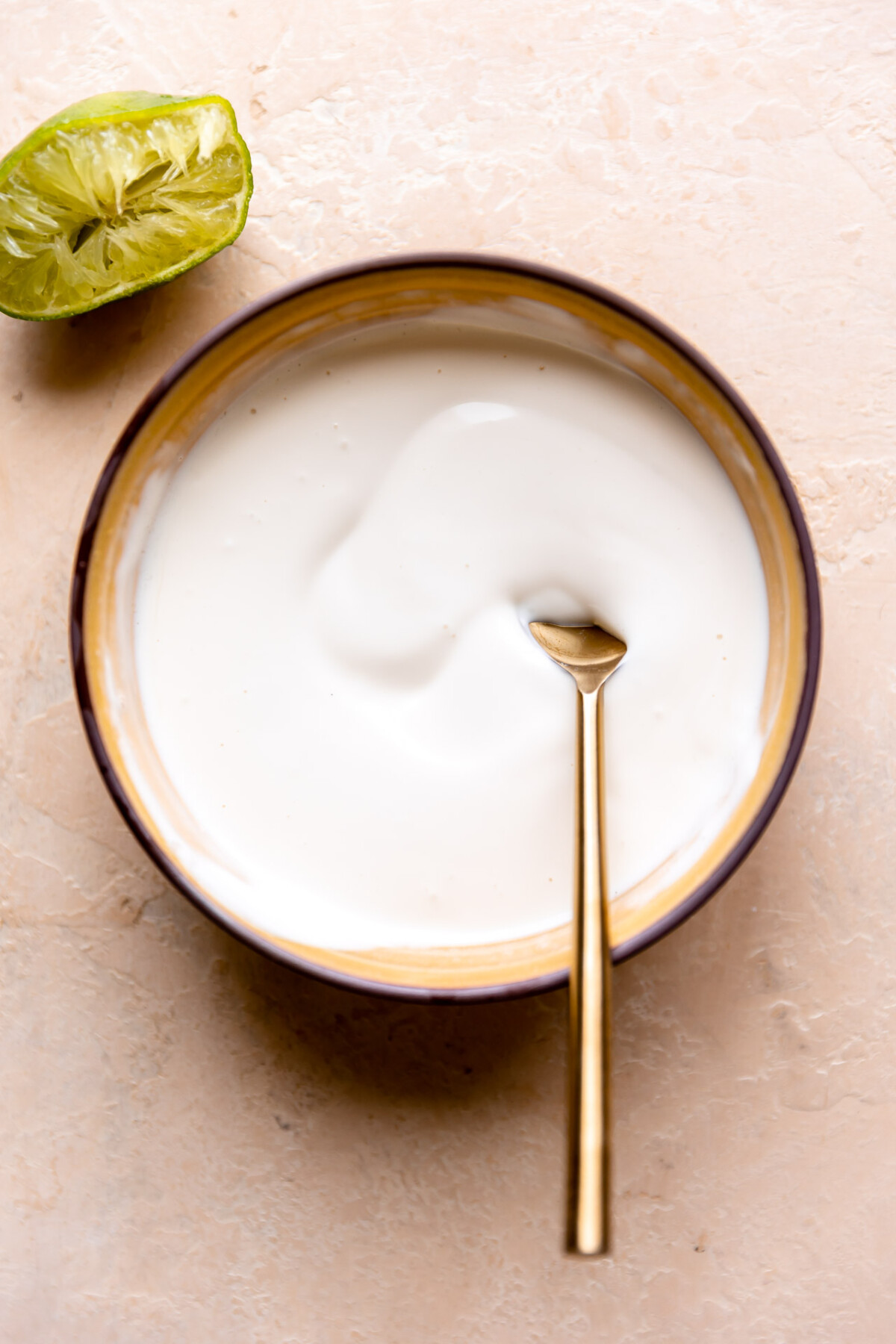 Bowl of tangy coleslaw dressing made with lime juice. 