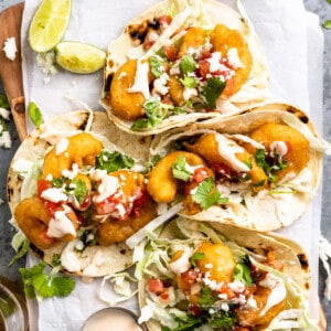 Tortillas filled with fried shrimp, creamy slaw, and topped with fish taco sauce.