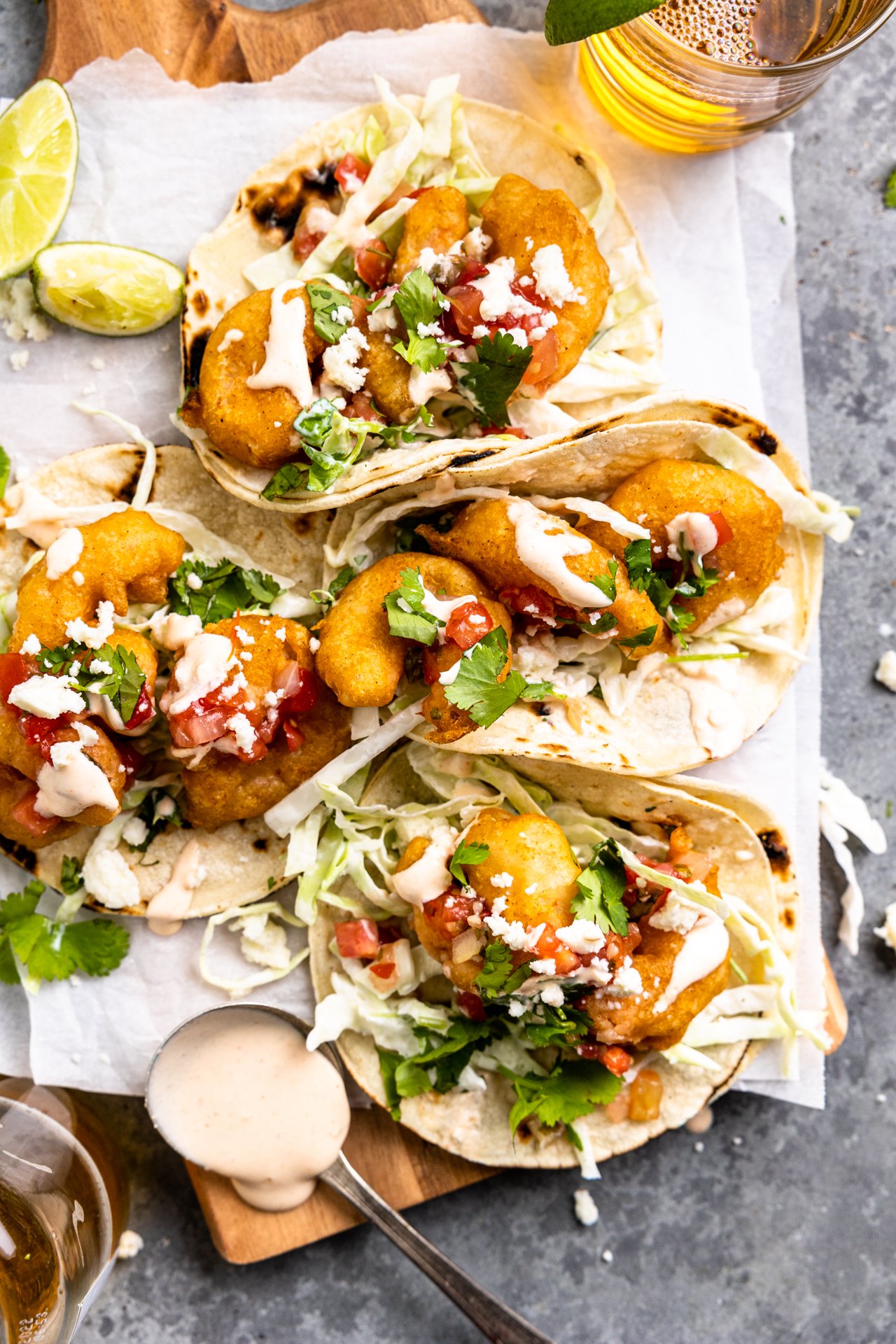 Baja Shrimp Tacos with fish slaw on a wooden board served with beer.