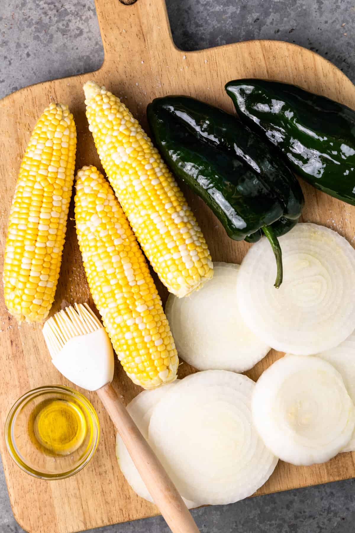 Vegetables on a wooden cutting board being prepped for grilling. 