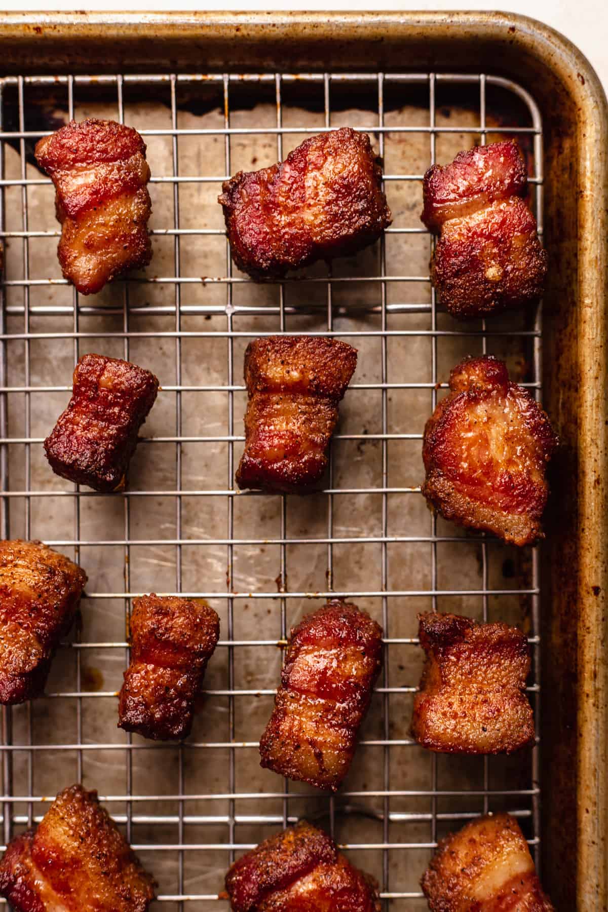 Smoked cubes of pork belly on a wire rack.