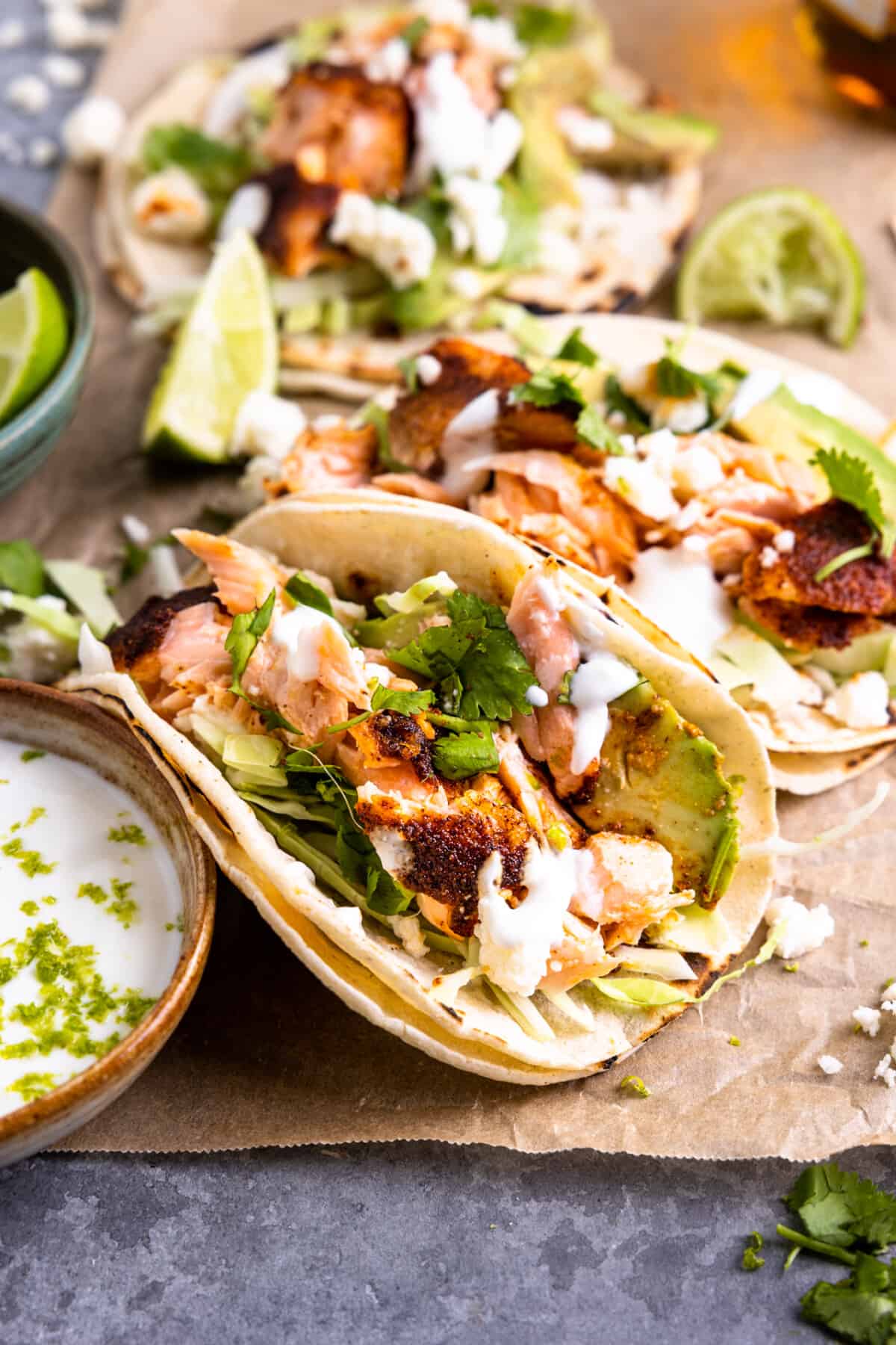 Salmon tacos served with fish taco slaw and lime wedges on the side. 