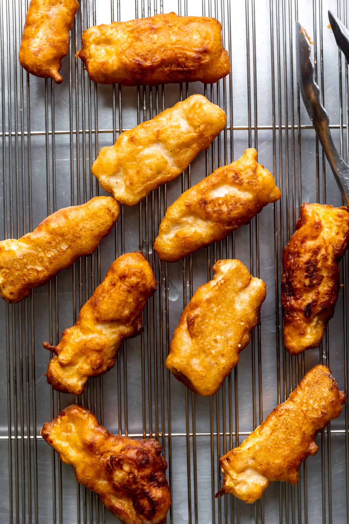 Fried fish on a wire rack to cool. 