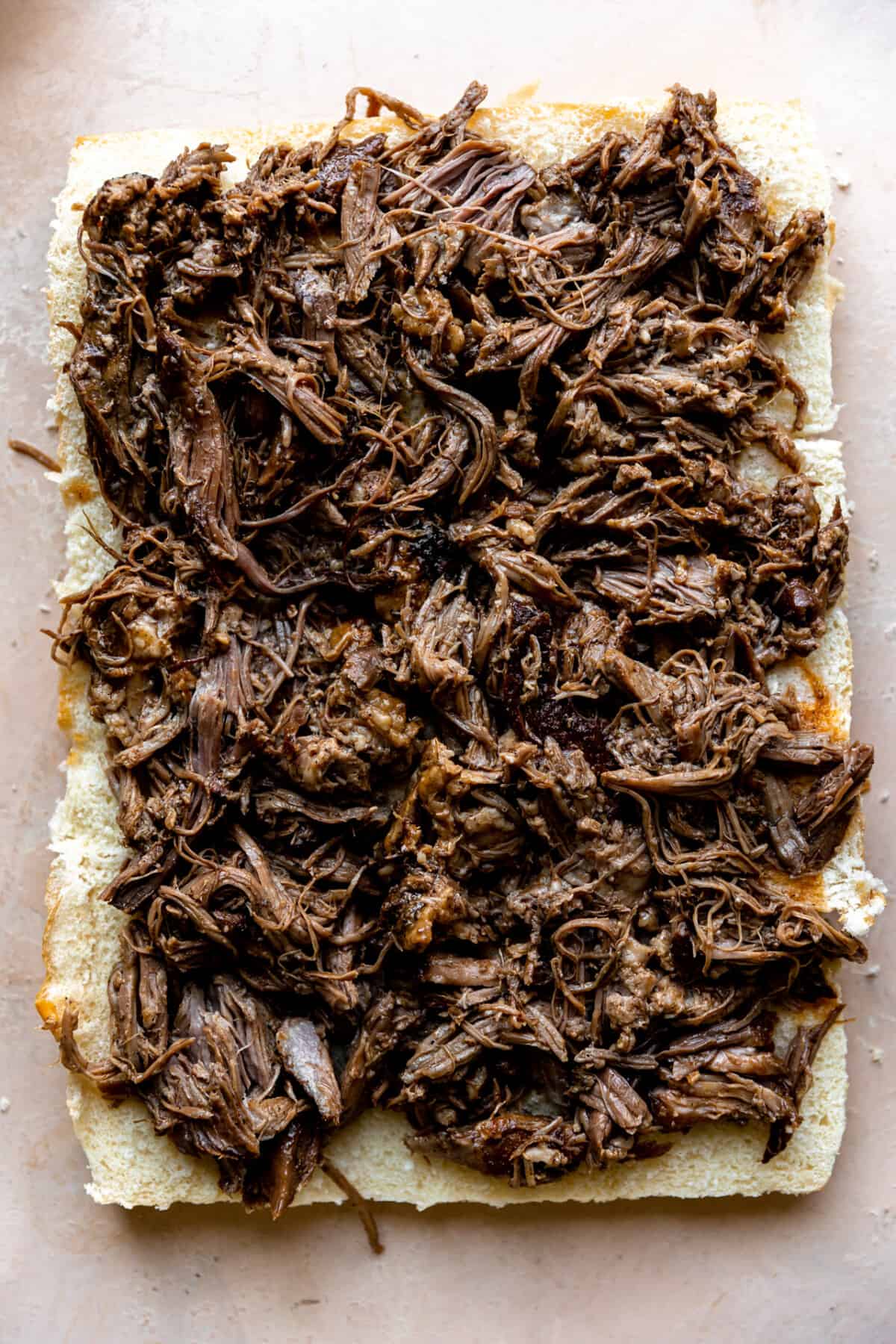 Shredded pulled pork on bottom slider buns.