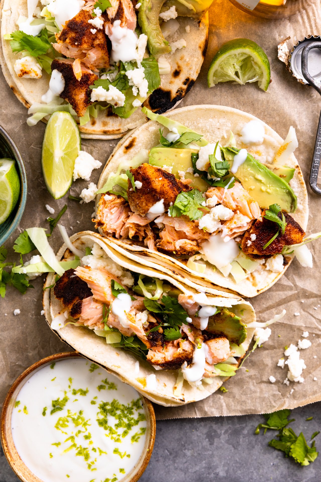 Tray of salmon tacos with slaw, avocado, and a cilantro lime crema.