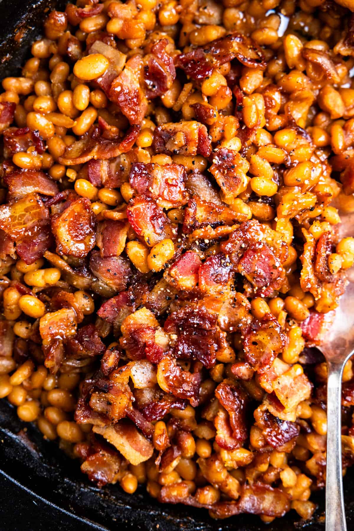 Crispy bacon on top of baked beans.