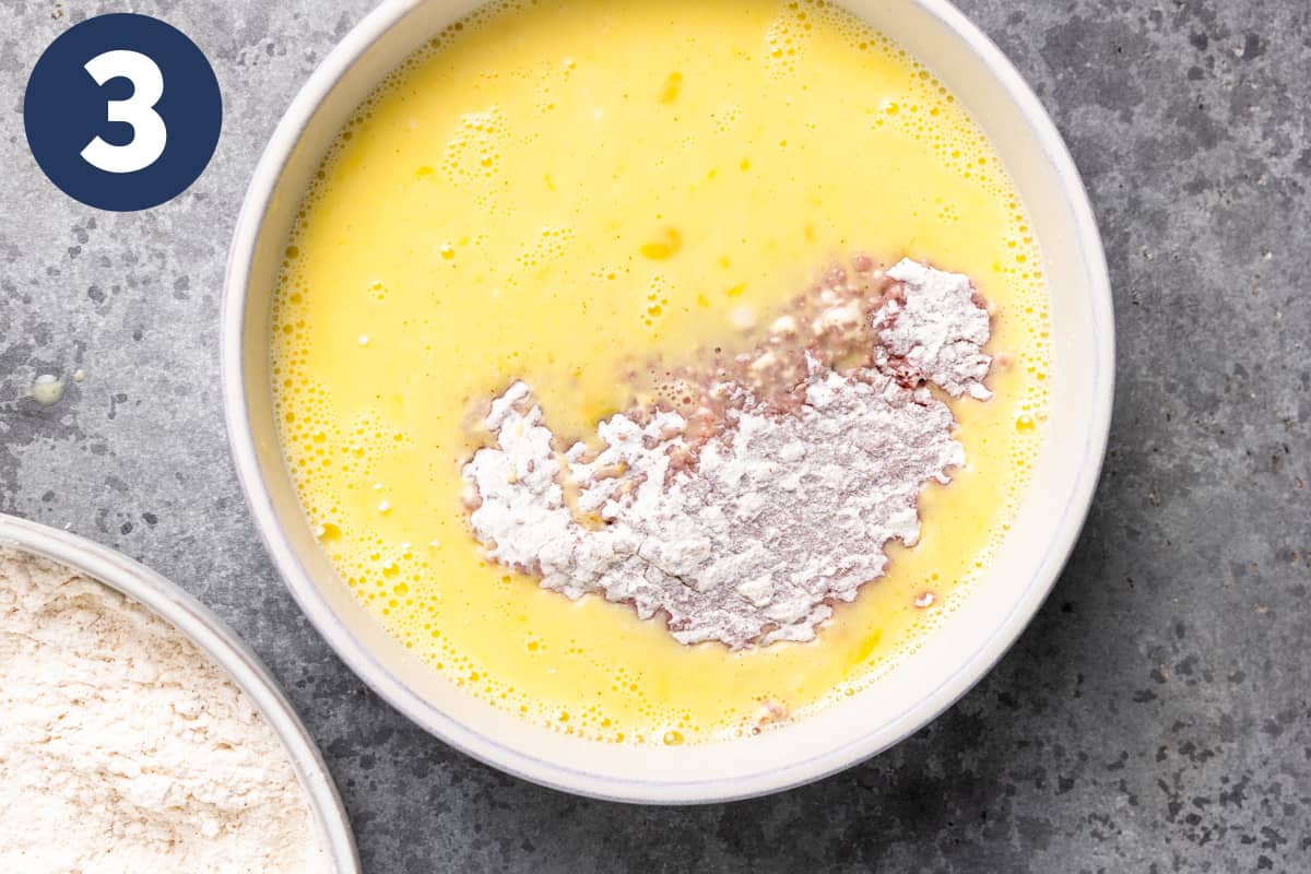Cube steak with flour and in a bowl of eggs.
