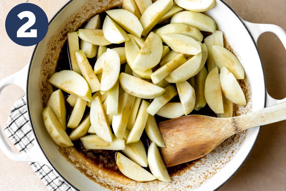 Cut apples added into a skillet with melted butter and spices.