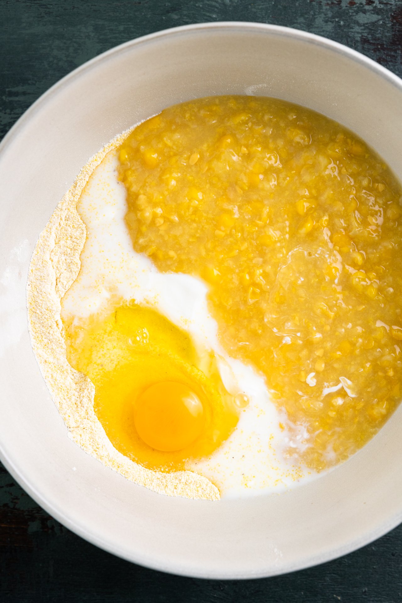 Creamed corn, egg and milk added to a dry mixture of cornmeal and flour to make a cornbread batter. 