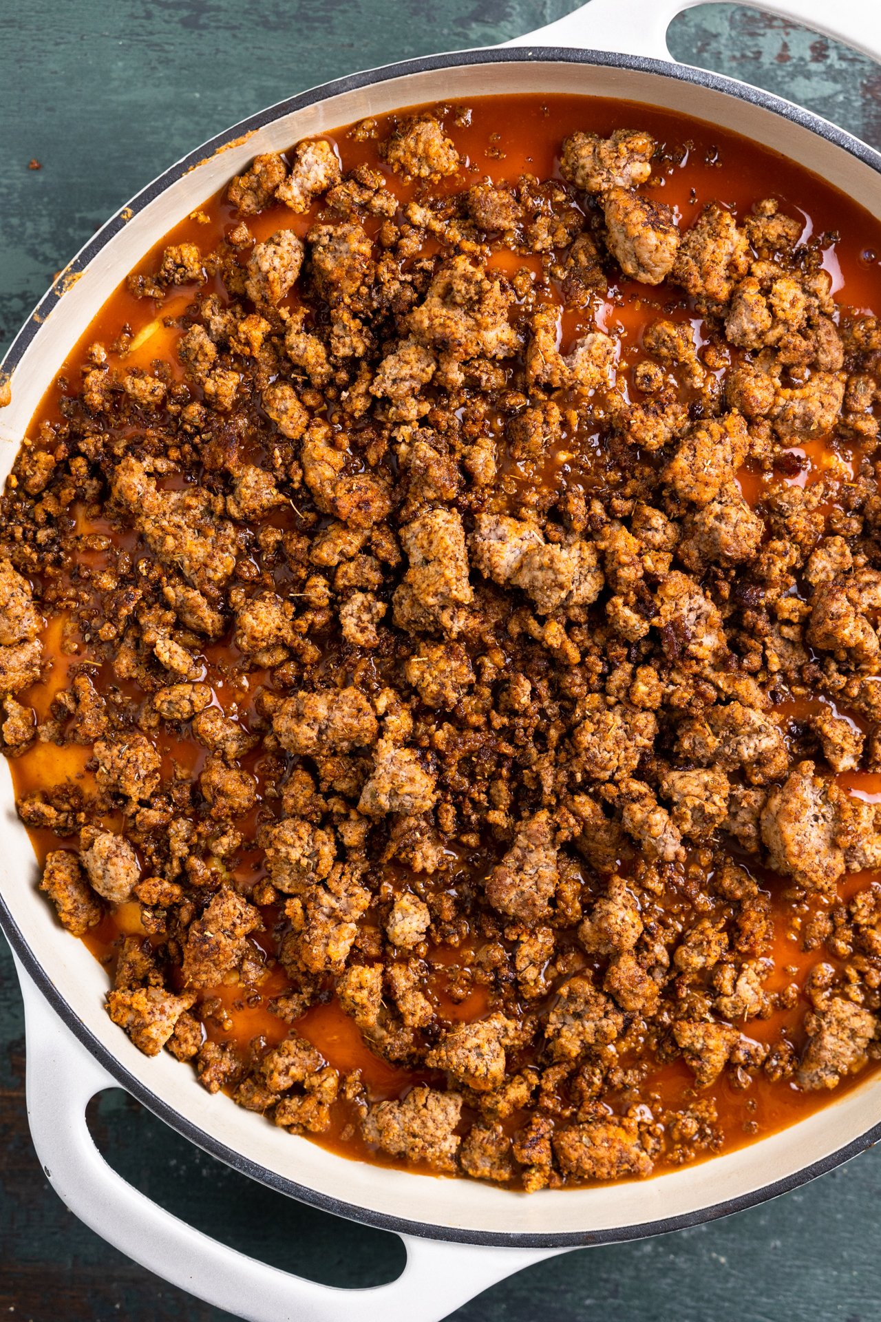 Cooked ground beef on top of cornbread soaked in enchilada sauce. 