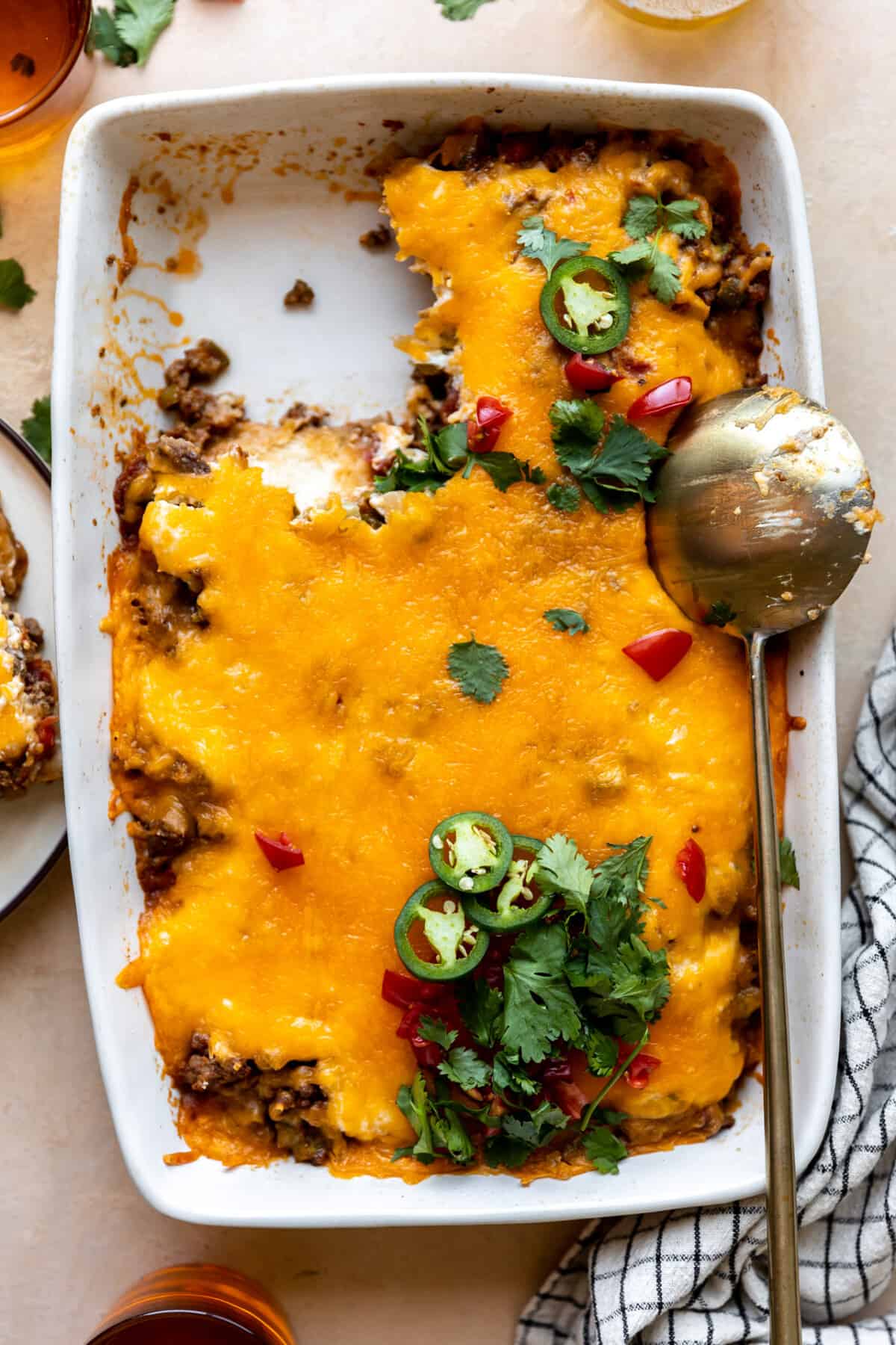 Baking dish with John Wayne Casserole with a portion served and a golden spoon on the side. 