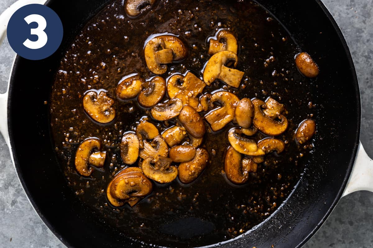Skillet with sliced and cooked mushrooms.
