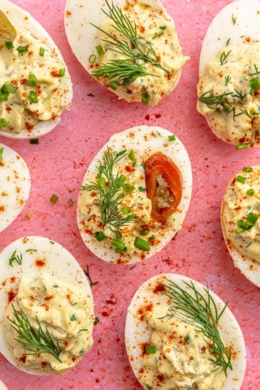 Deviled eggs topped with fresh dill and pickled jalapeño slices.