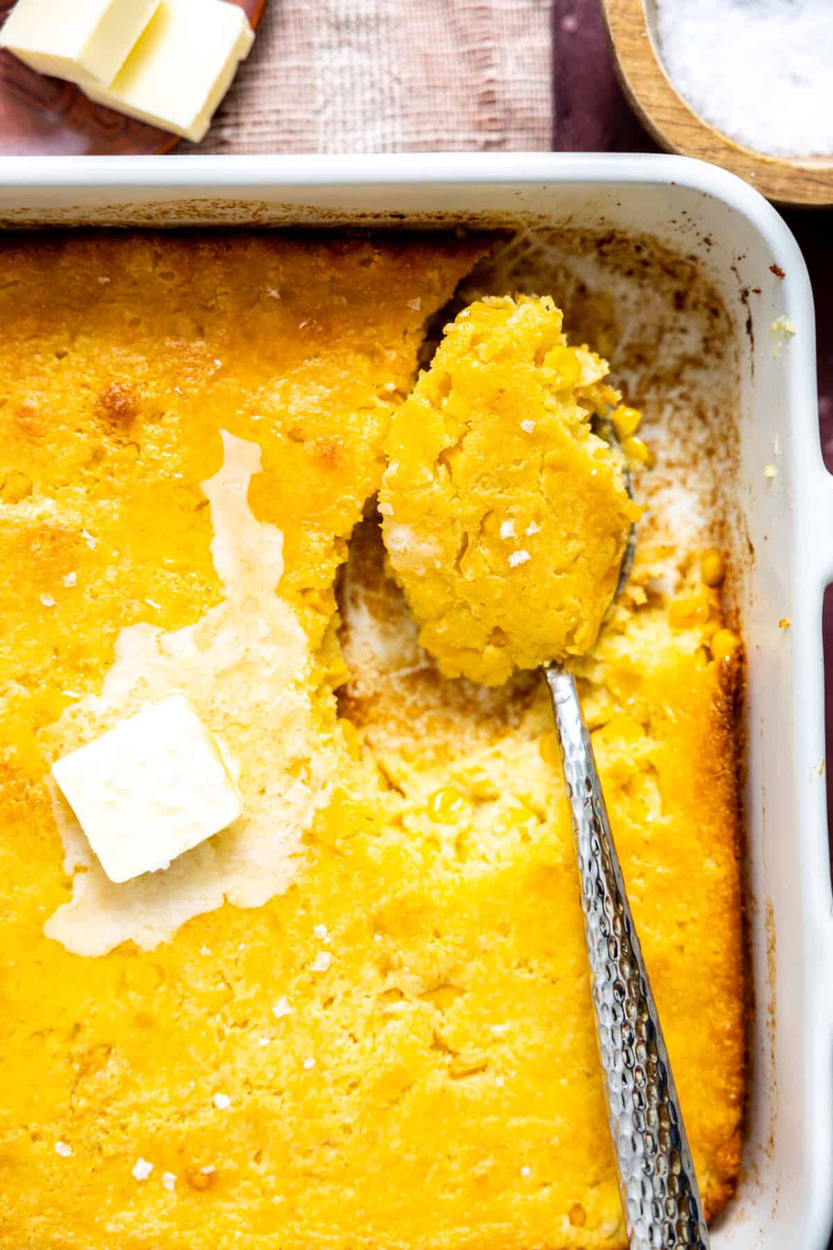 Spoon dishing up cornbread casserole.