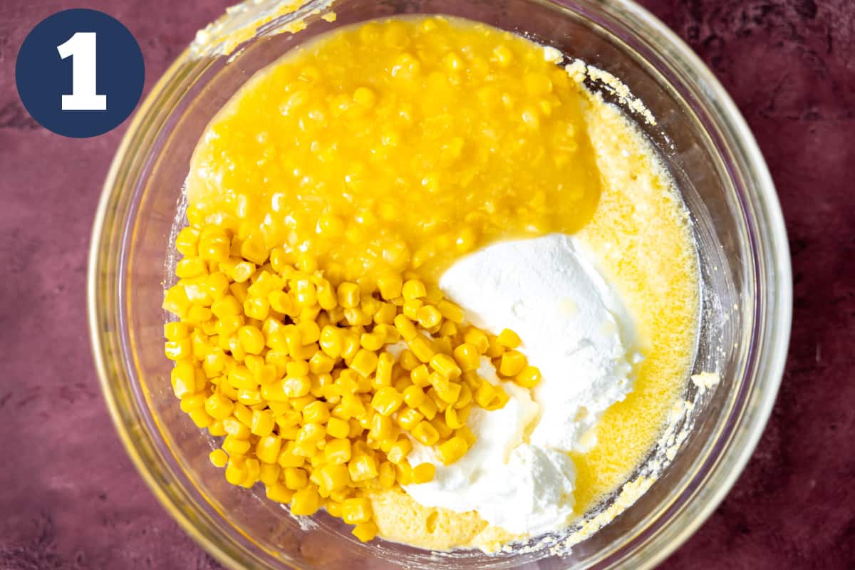 Bowl filled with ingredients for corn casserole. 