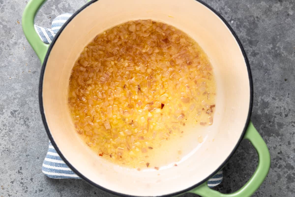 Sautéing shallots in butter inside a dutch oven. 