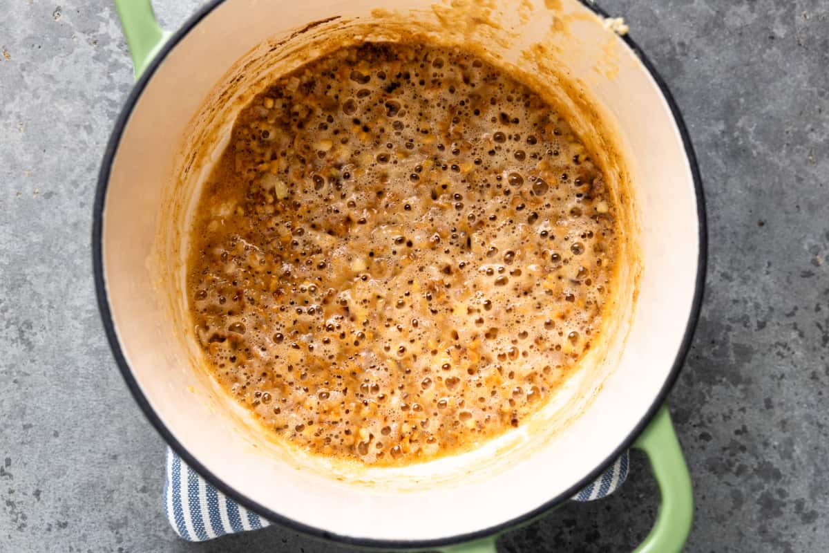Cooking flour with butter and shallot for making gravy.