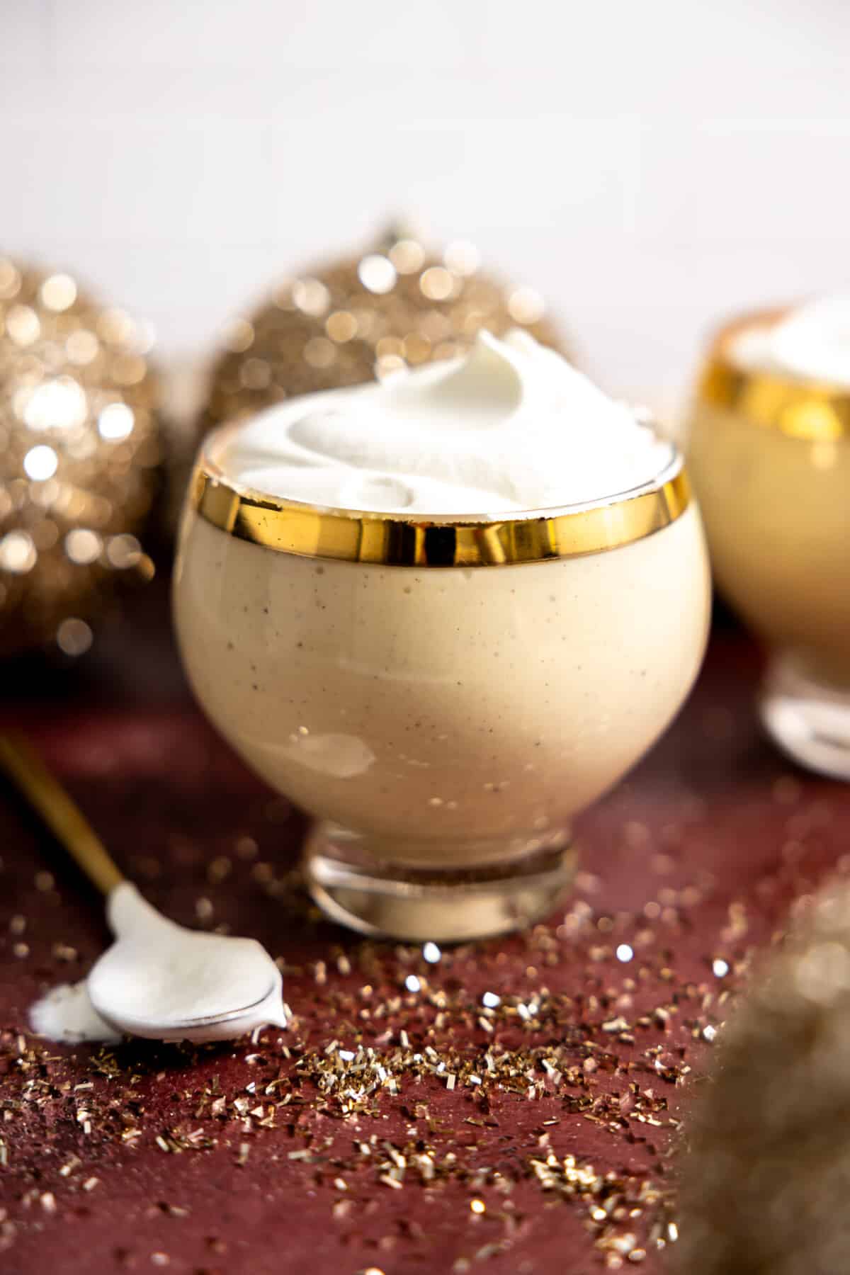 Glass of eggnog topped with whipped cream.