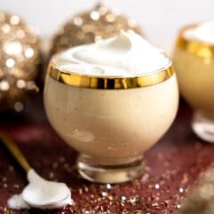 Glass of eggnog topped with whipped cream.