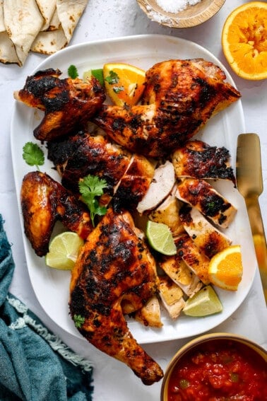 Plate of pollo asado served with tortillas on the side.
