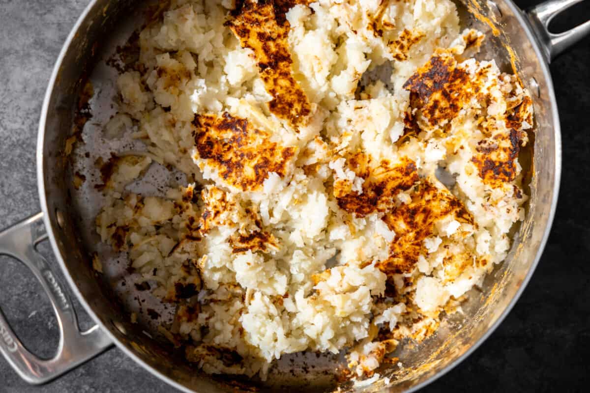 Cooking frozen shredded hashbrowns in a skillet. 