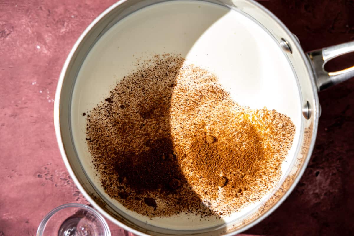 Milk, cream and nutmeg in a saucepan.